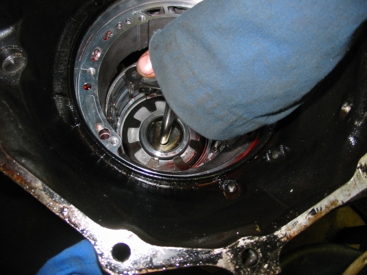 Compressing return spring to remove snap ring, spring and low / reverse piston
